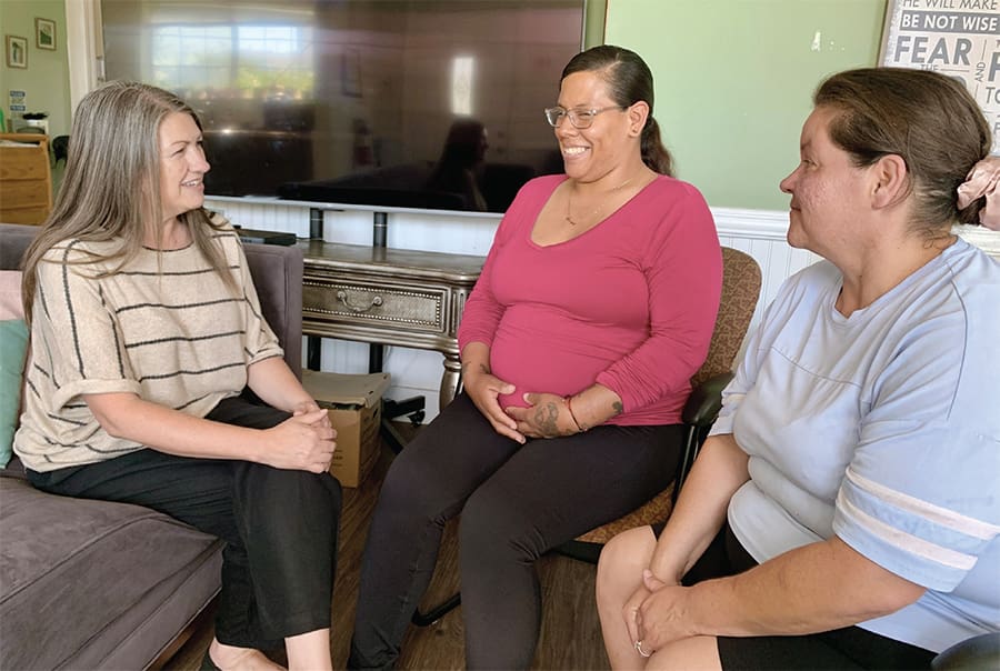 Leslie Painter (left), director of the Lighthouse for Women and Children, chats with residents at the Lighthouse Life Recovery Program home.