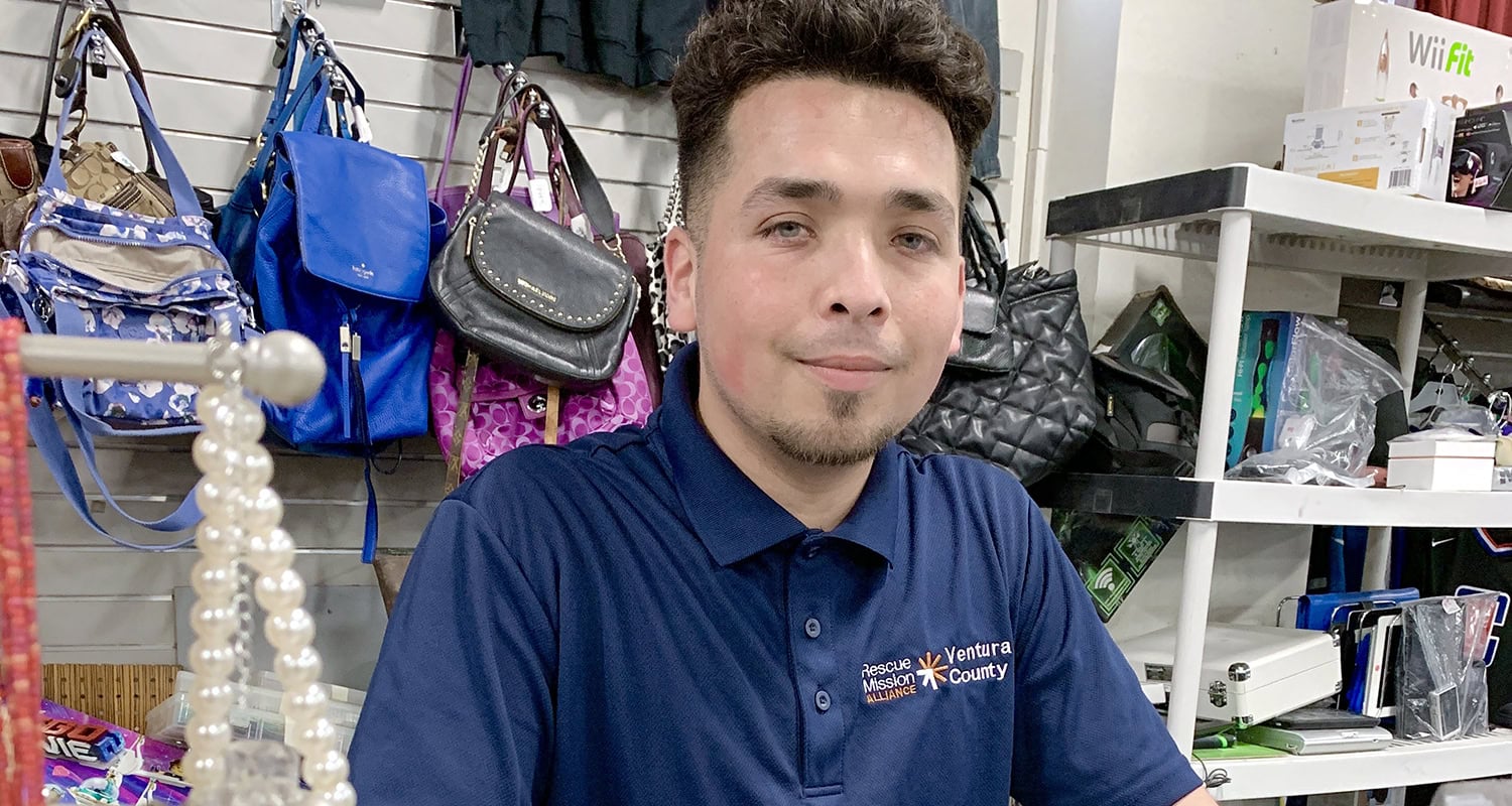 Rescue Mission Alliance Ventura County staff member assisting customers at donation center.