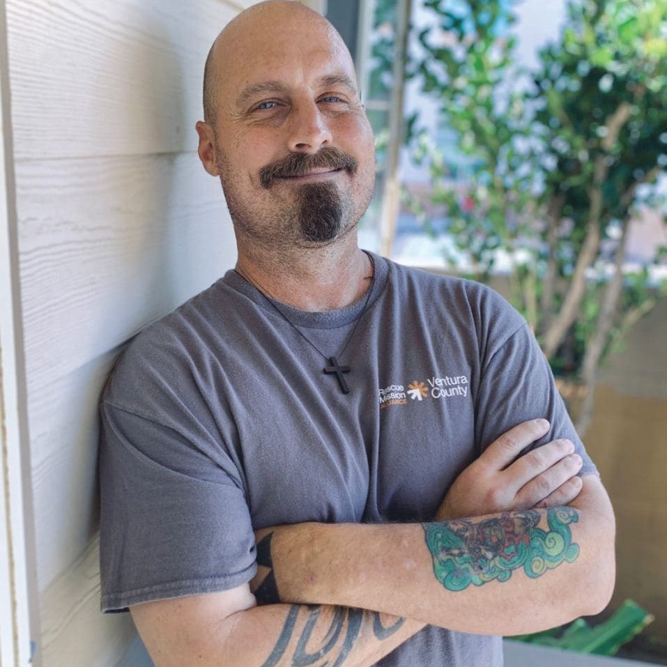 Rescue worker from Ventura County smiling outdoors with arms crossed.