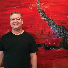 Man Smiling in Front of Art