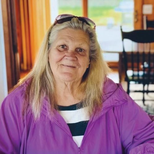 A woman smiling inside a community center at Rescue Mission Alliance Ventura County.