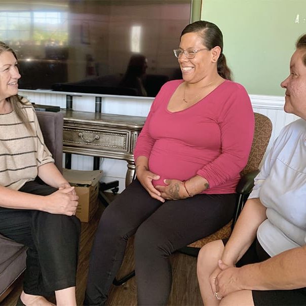 Leslie Painter (left), director of the Lighthouse for Women and Children, chats with residents at the Lighthouse Life Recovery Program home.