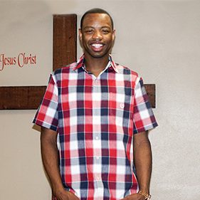 Man Smiling in Front of Cross